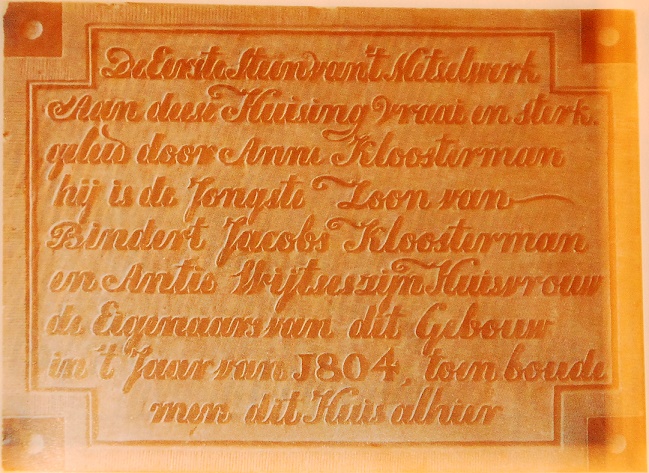 De eerste steen van `t metselwerk
aan deese huising vraai en sterk
geleid door Anne Kloosterman
hij is de jongste zoon van
Bindert Jacobs Kloosterman
en Antie Wijtses zijn huisvrouw
de eigenaars van dit gebouw
in`t jaar van 1804, toen boude
men dit huis alhier De eerste steen van `t metselwerk
aan deese huising vraai en sterk
geleid door Anne Kloosterman
hij is de jongste zoon van
Bindert Jacobs Kloosterman
en Antie Wijtses zijn huisvrouw
de eigenaars van dit gebouw
in`t jaar van 1804, toen boude
men dit huis alhier